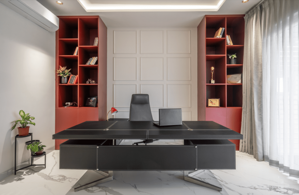 Home office design with black executive desk and symmetrical bookshelves in Pune