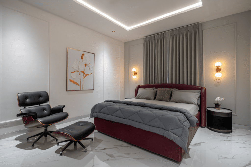 Bedroom design with maroon leather bed and Eames lounge chair in Pune