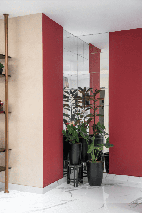 Entryway design with maroon and cream color-blocked walls and potted plants in Pune