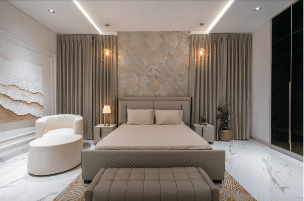 Luxury bedroom interior design with beige tones, backlit accent wall panel, and marble flooring in Pune