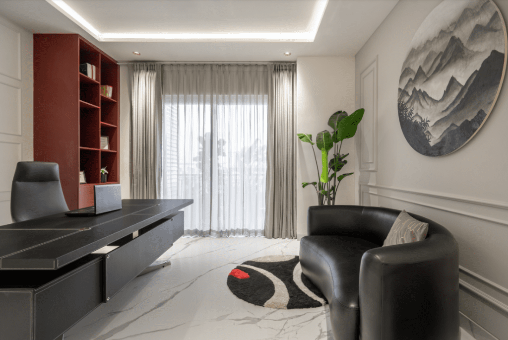 Modern home office design with wooden desk, black leather chairs, and mountain wall art in Pune
